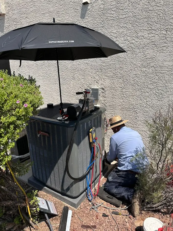 HVAC technician performing outdoor AC maintenance in Sandy
