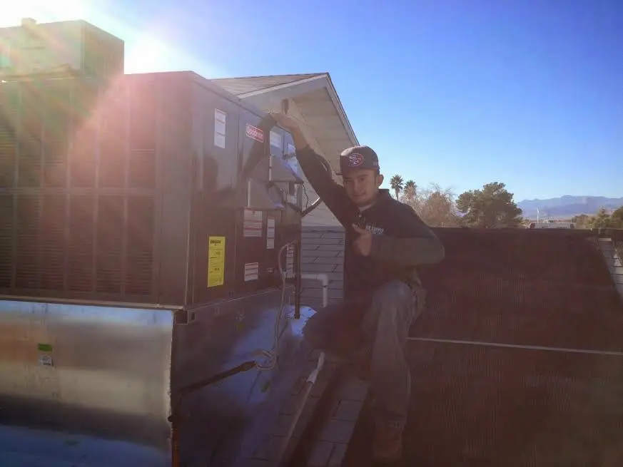 HVAC technician performing Boiler Repair on a rooftop unit in Sandy